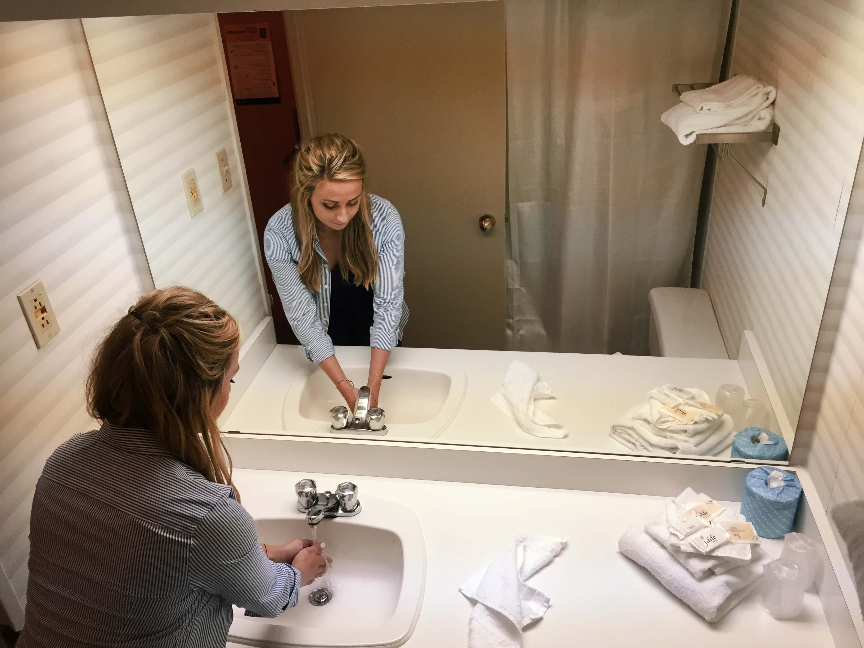 Individual washing hands in bathroom